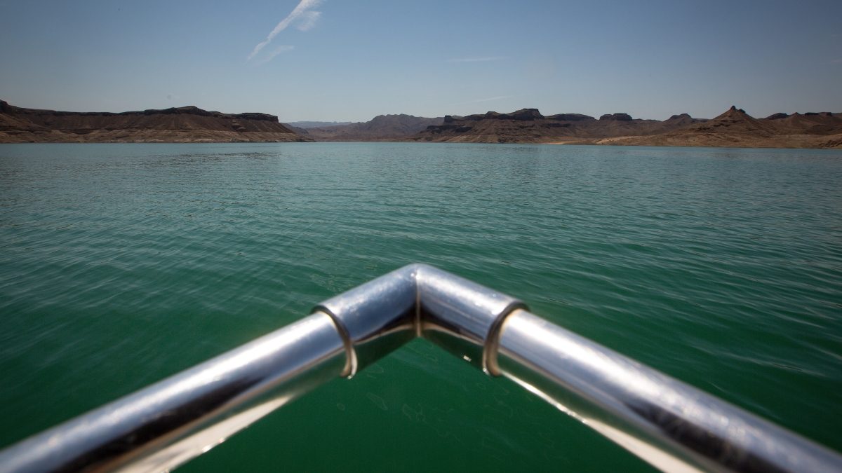 The front railing of a boat is seen above the waters of Lake Mead