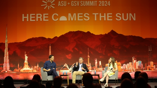 Three people sitting on stage for panel with an image of mountains as a background and words reading "ASU + GSV Summit 2024" and "Here Comes The Sun"