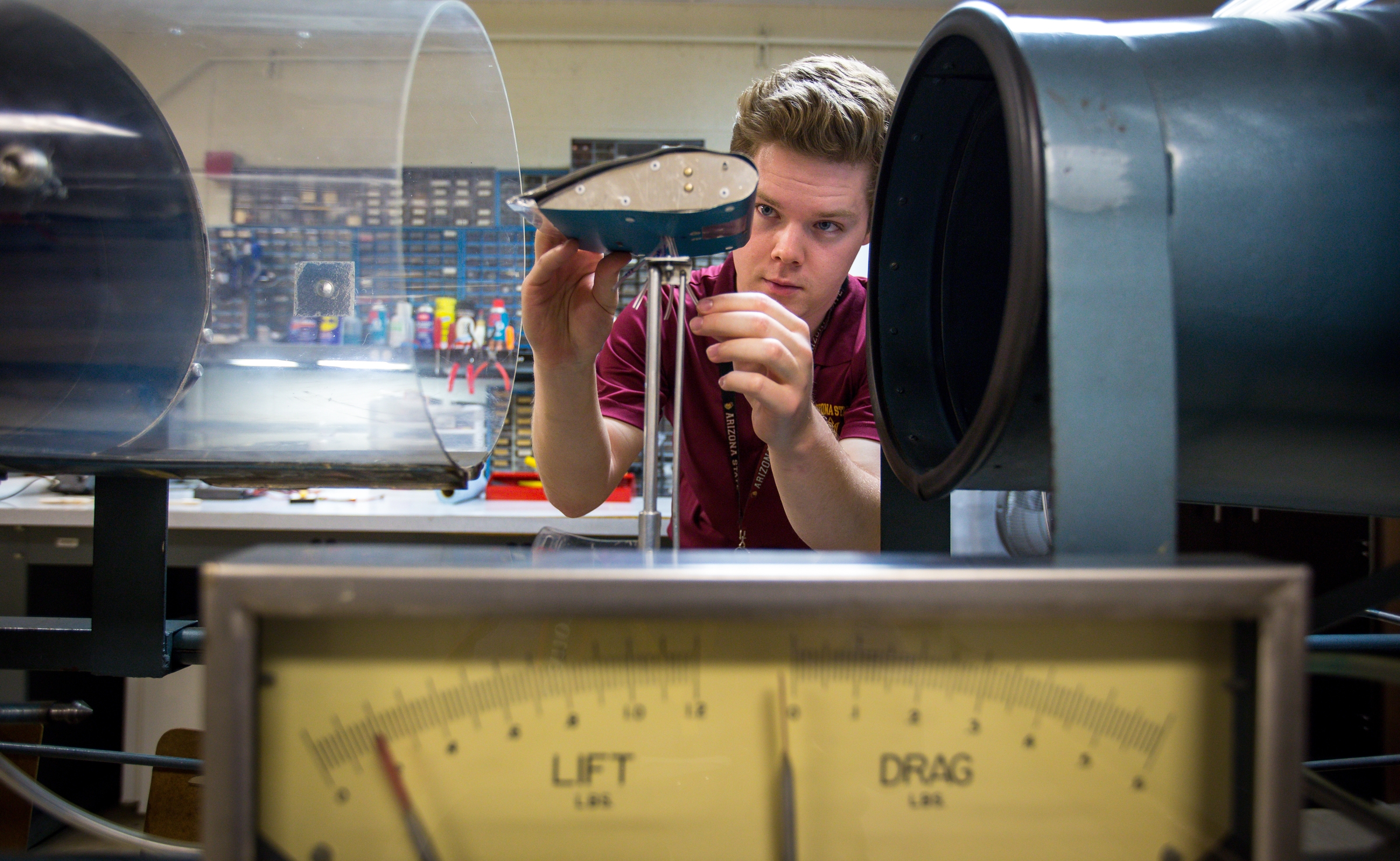 Aviation student Eamonn McIntyre adjusts a miniature wing in a wind tunnel.