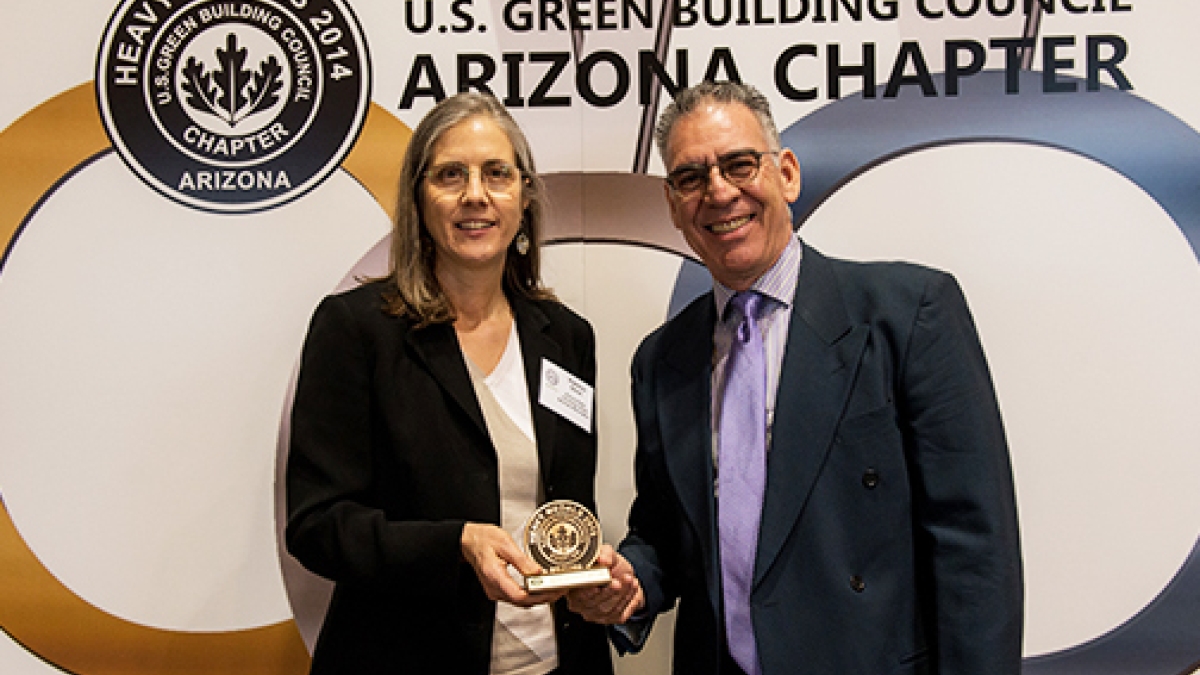 P. Olson and E. Soltero pose with a USGBC Heavy Medal award 