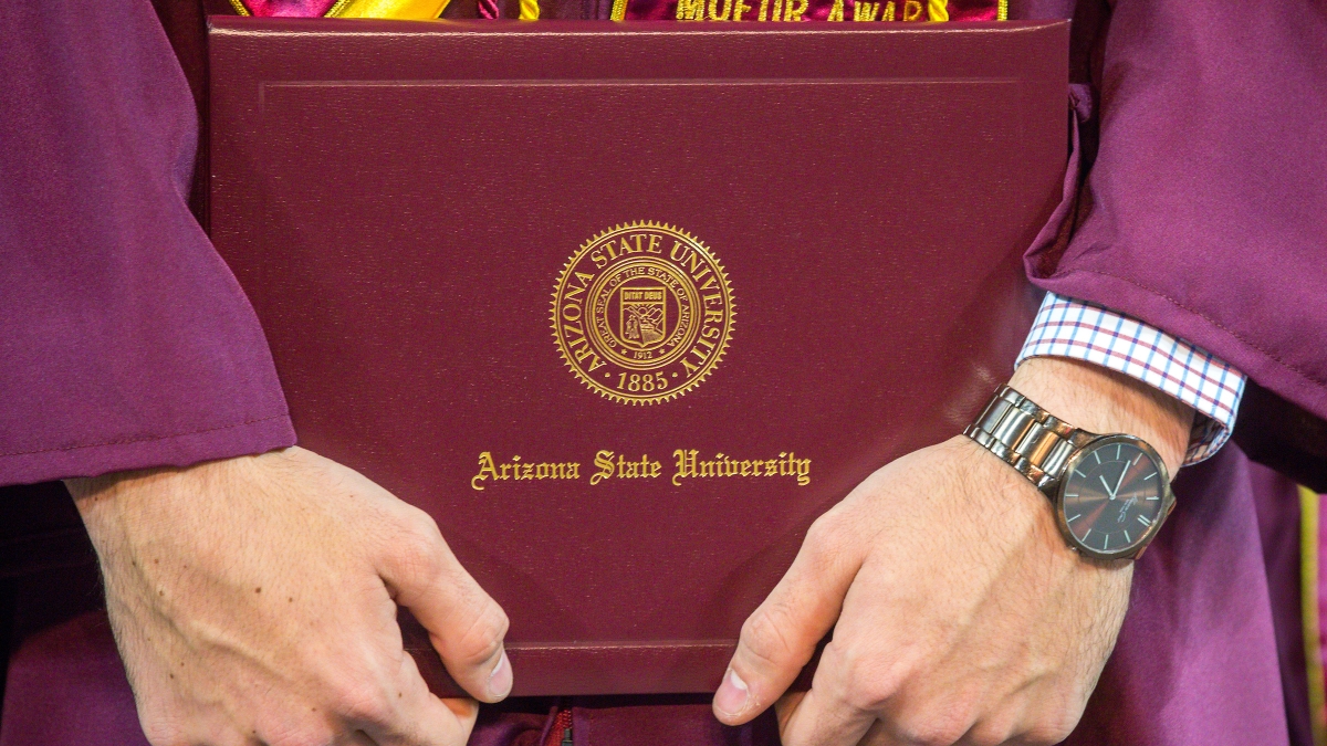A new graduate holds his diploma