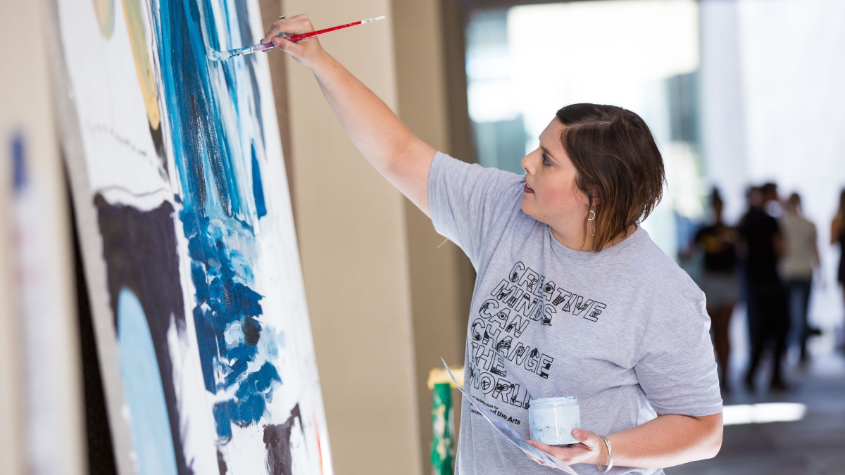 Photo of Heidi Hogden painting a mural at Herberger Institute Day