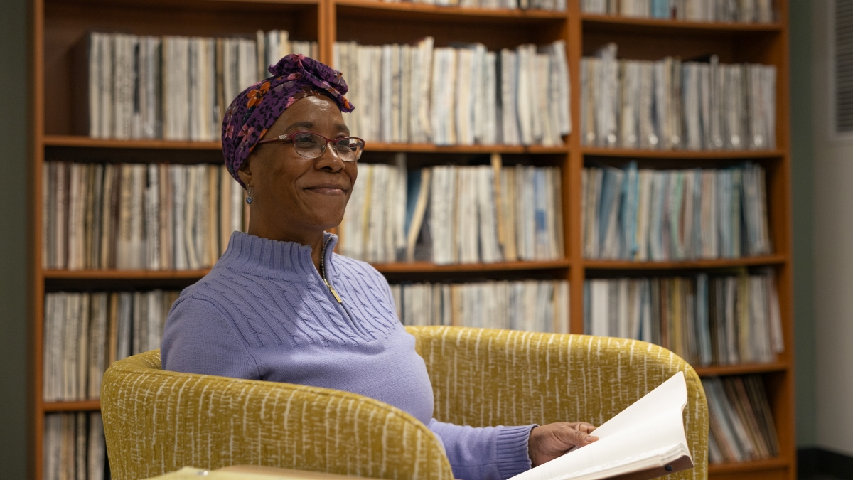 ASU student Shirley A. Mitchell-Valrie smiles off-camera sitting in front of a bookshelf