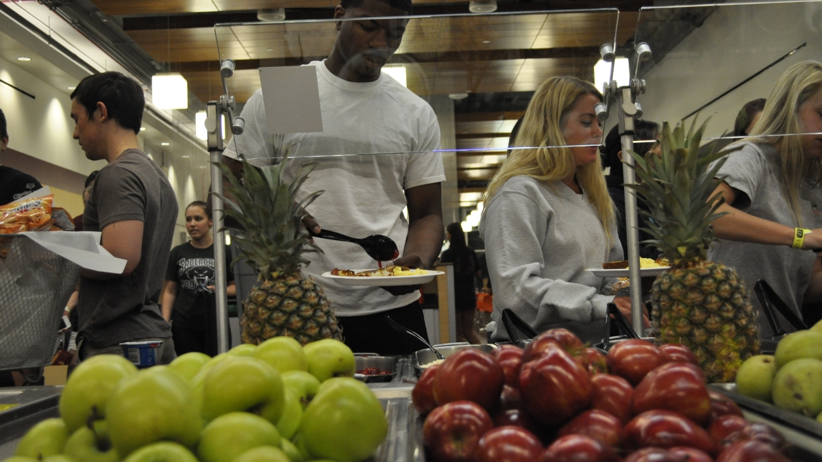 students in line dish fruit onto their plates