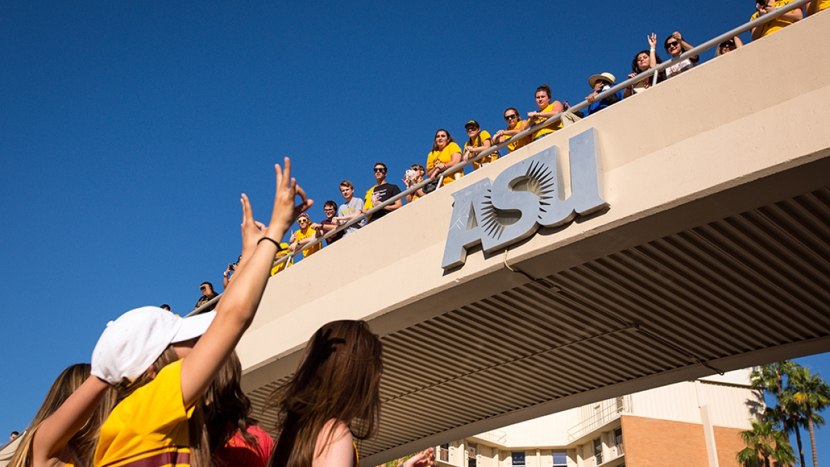 people waving from ASU bridge