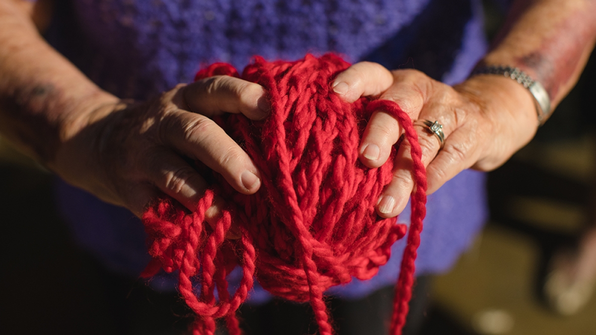 woman's hands holding ball of yarn