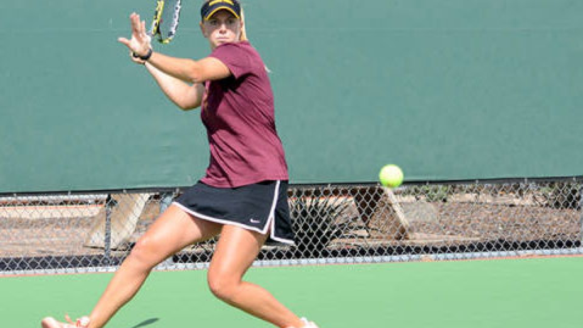 ASU women's tennis player swinging racket at ball