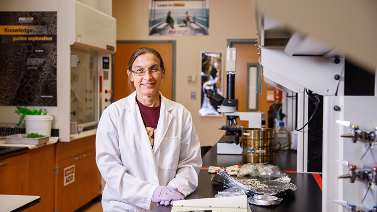 A woman stands in a laboratory, surrounded by scientific equipment. The caption reads: Beth Polidoro is a marine biologist who leads ASU’s Salt Water Assessment Team (SWAT) lab, and an associate professor of environmental chemistry and aquatic conservatio