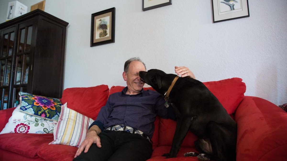 man and dog on couch