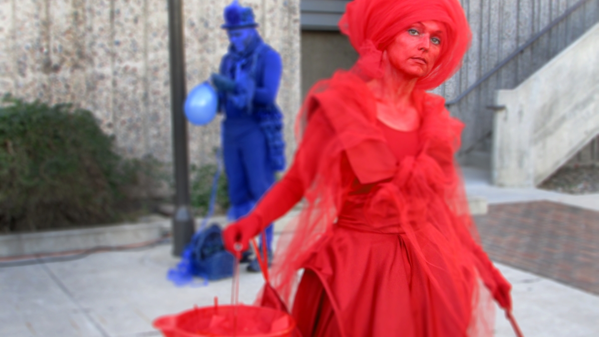 Two performers, one clad entirely in red, and another entirely in blue