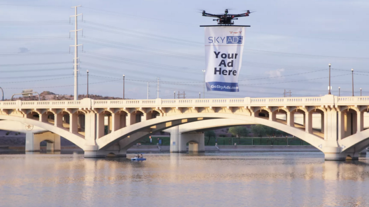 A drone carries a banner ad over Tempe Town Lake