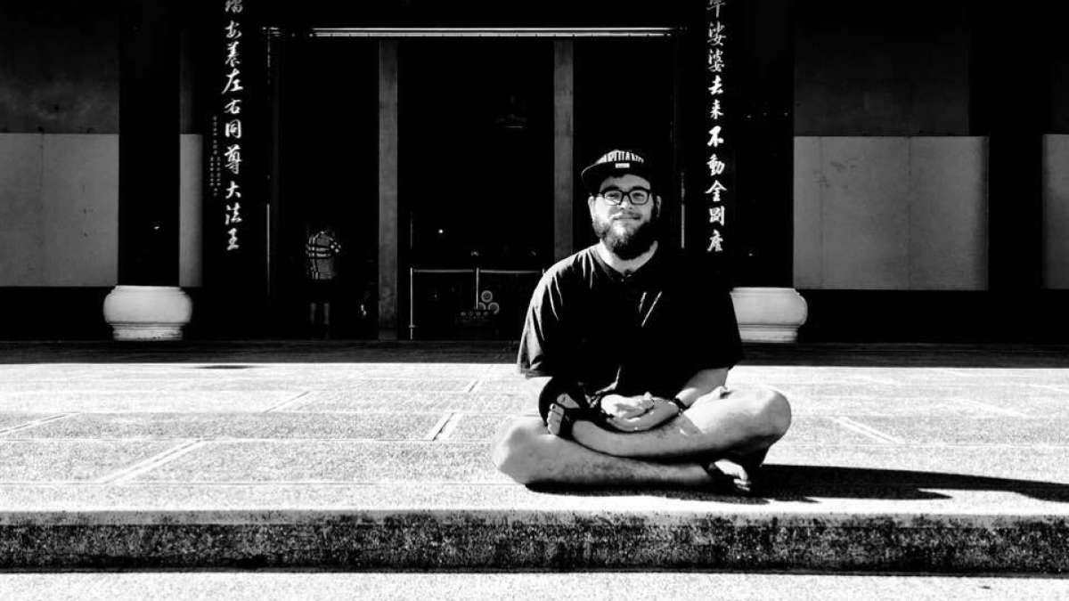 Nathaniel Harris sits in front of a temple