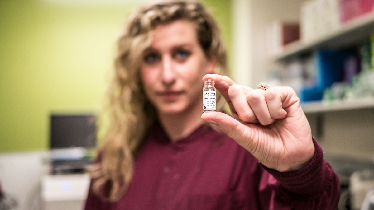 ASU grad student holding a vial