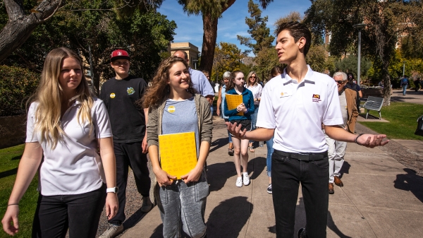 male student leading tour group of potential students and their parents on the ASU Tempe campus