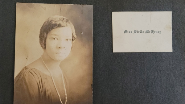 A page from an old photo album shows a sepia-tone portrait of a Black woman from the 1920s in formalwear and a name card that reads Miss Stella McHenry