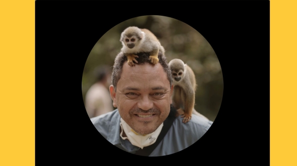 Marcos Colón with monkeys on his shoulder and head.