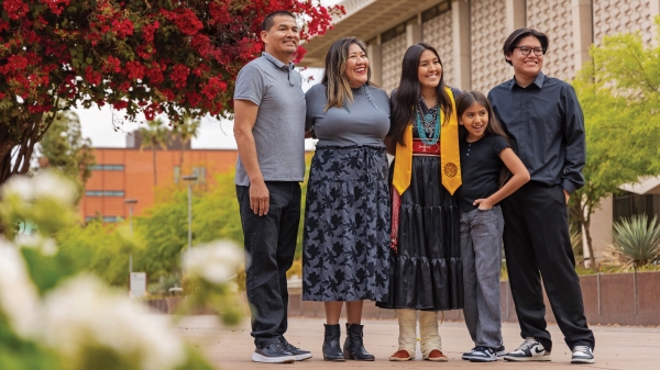 Graduating student poses with family on ASU's Tempe campus