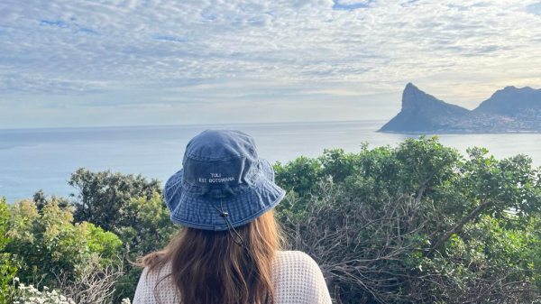 A woman in a bucket hat staring out at the ocean.