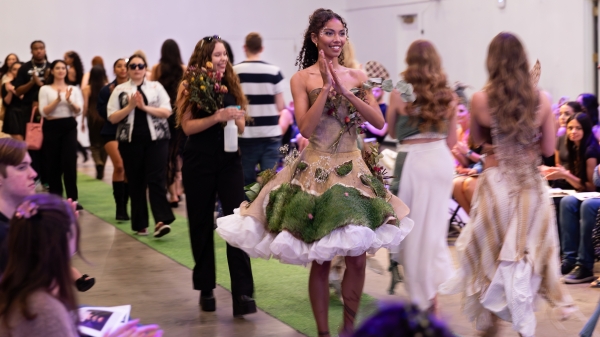 Students walk on a fashion show runway