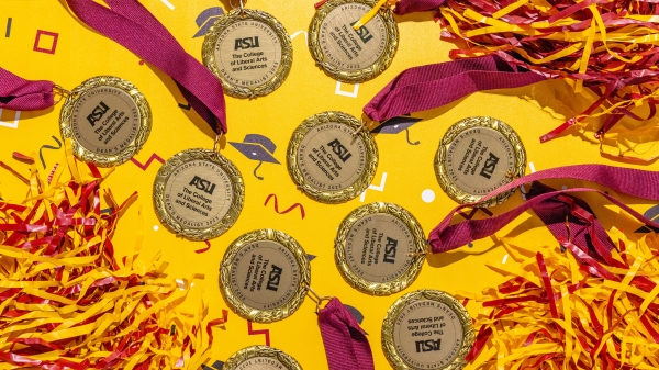 Several medals laying flat on a gold and maroon background.