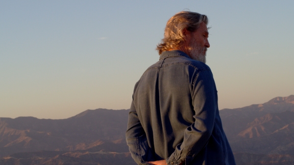 still of man with mountains behind him from documentary