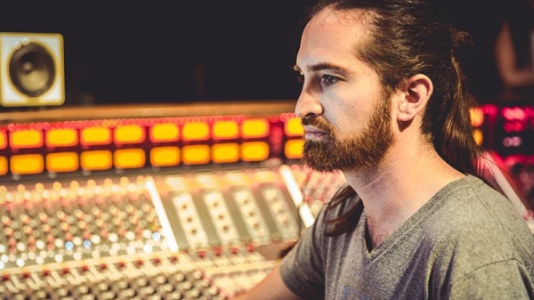 International music engineer Jorge Costa Palazuelos sitting in a music studio with a mixing board in the background.