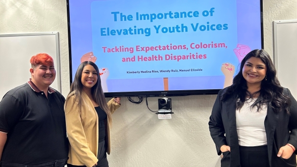 Manuel Elizalde, Wendy Ruiz, Kimberly Rios standing in front of a screen that reads "The importance of Elevating Youth Voices" with smaller text underneath