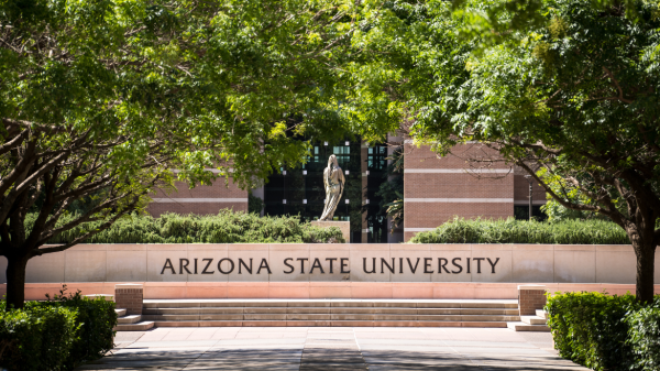 View of Fletcher Lawn on ASU's West campus, featuring a stone statue of a woman in a cloak, a sign reading "Arizona State University" and a pathway surrounded by trees.