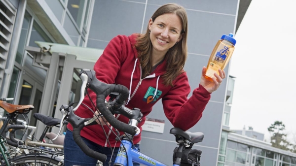 woman next to bike holding water bottle