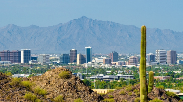 The Phoenix Arizona skyline with desert mountains in the foreground and background