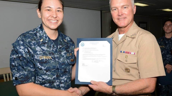 Vice Admiral Thomas Rowden awards Ensign Rachelle Edwards her surface warfare officer pin.