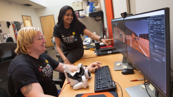 Software engineering major Kaycee Nienhuis and computer science graduate student Radhika Ganapathy look at images on a computer screen with a virtual reality headset on a desk as part of MORE research with the Ira A. Fulton Schools of Engineering at ASU.
