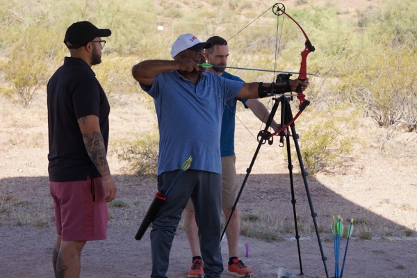 James Malone shoots an arrow as Rick Alvarado and Josh Parks watch