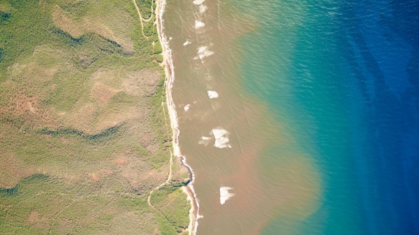 Aerial view of plumes of turbid water on a beach in Molokai, Hawaiʻi.