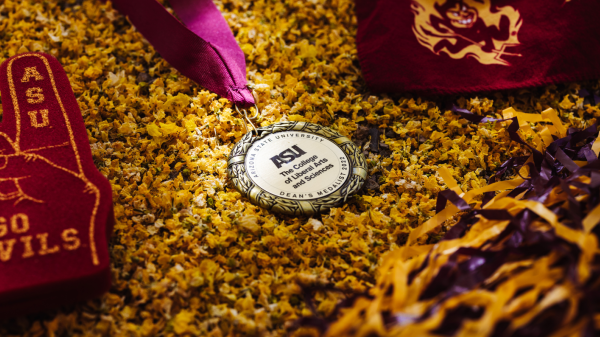 The College Dean's medal surrounded by gold flowers and sprit gear.