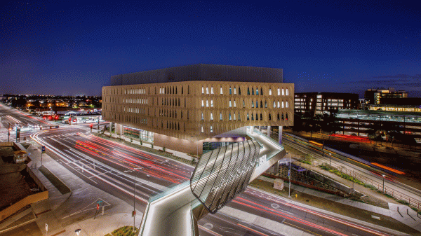 A night photo of an exerior of a building with traffic blurred in the foreground.