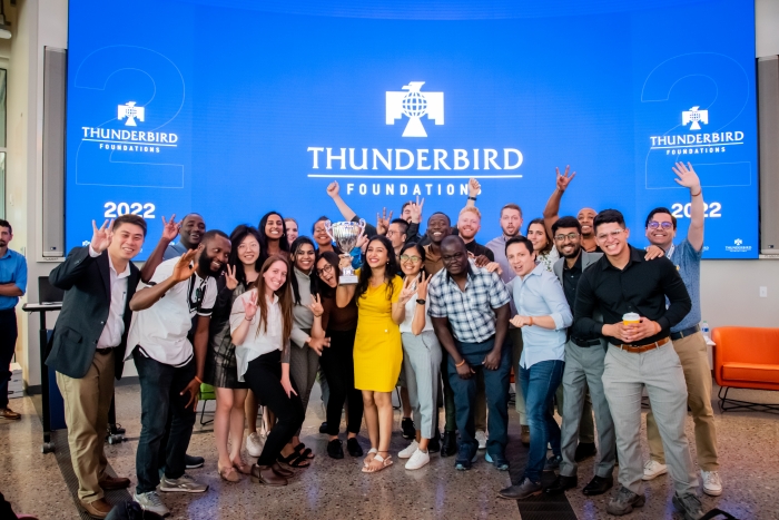 Gupta (center, holding trophy) at Foundations, Thunderbird's new student orientation, at Thunderbird Global Headquarters. 