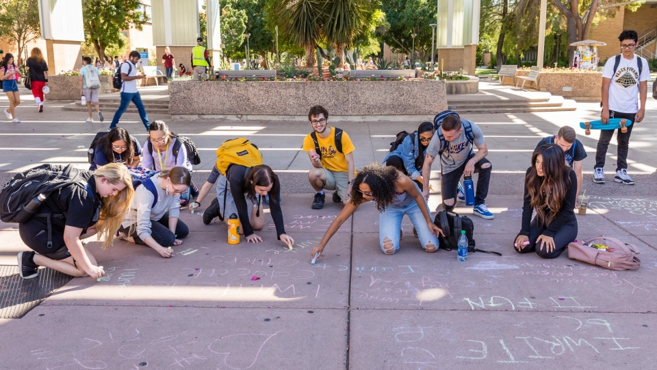 Image of ASU students writing with chalk during National Day on Writing activities 2019, photo by Bruce Matsunaga