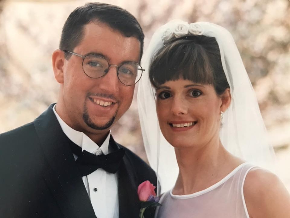 smiling man wearing tuxedo and smiling woman wearing wedding gown