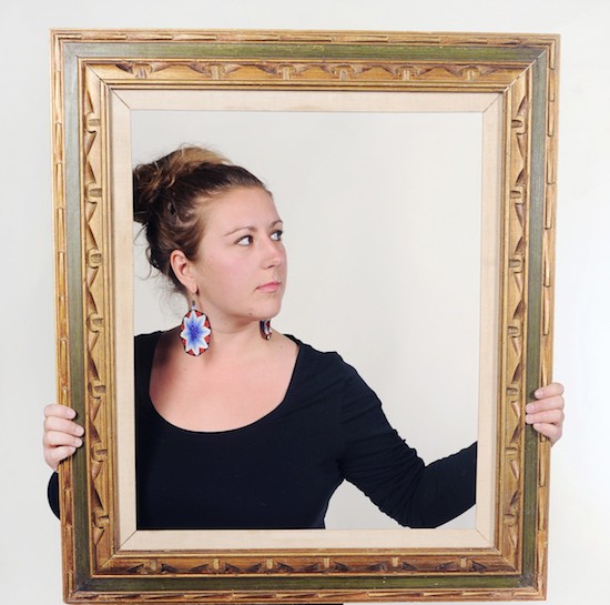 portrait of woman standing behind picture frame
